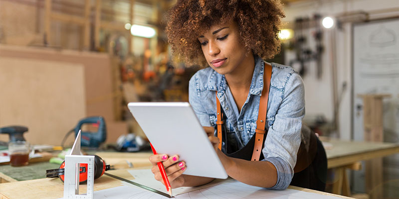 woman at a workshop looking at a tablet screen