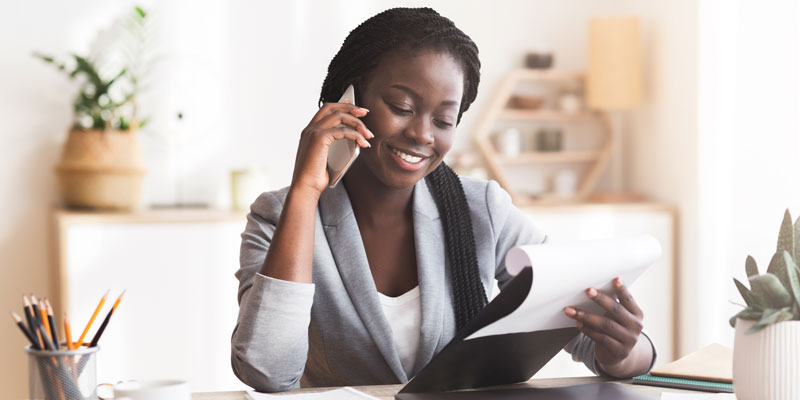 women on phone holding a clipboard