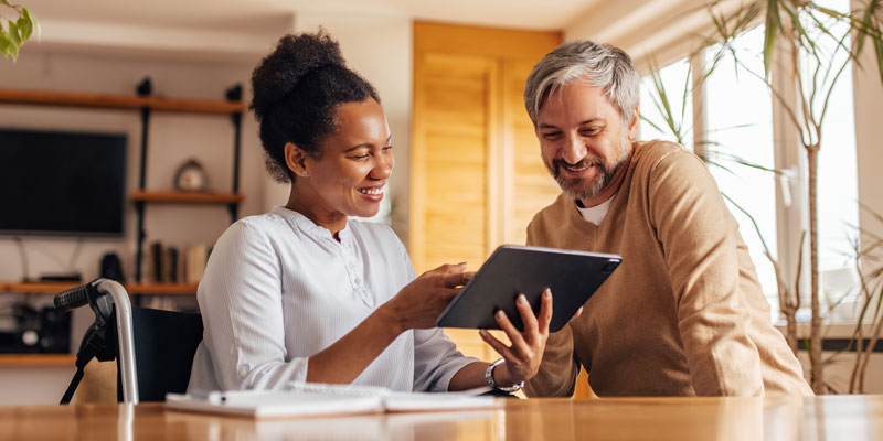 two people reviewing information on a tablet