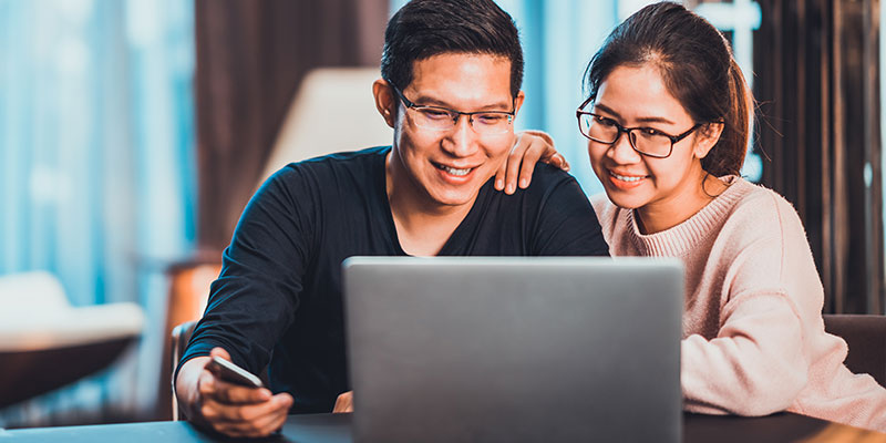 Couple excited viewing laptop