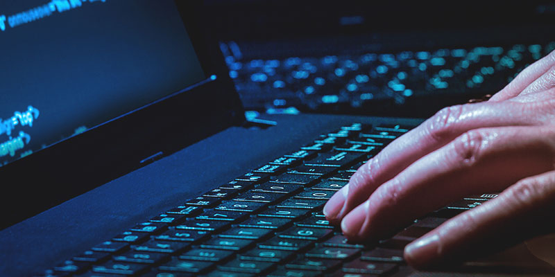 Close up of person's hand on laptop keyboard