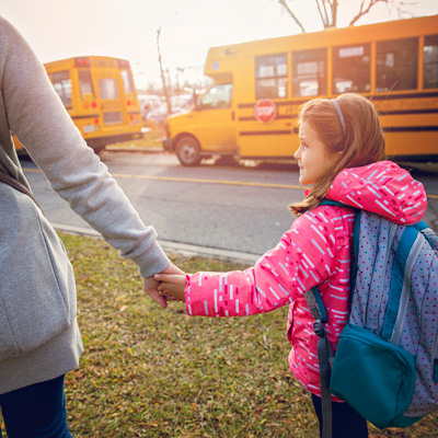 Mom walking daughter to school bus