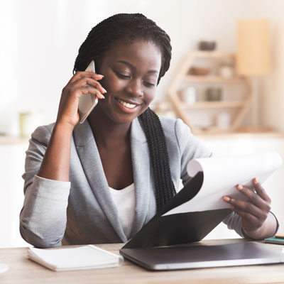 Woman in office on a phone looking at papers