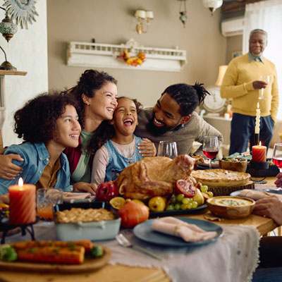 people sitting and standing together at table full of food