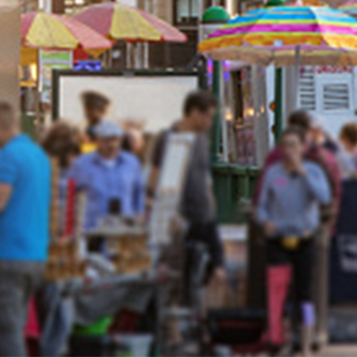 crowd of people with hot dog carts in background