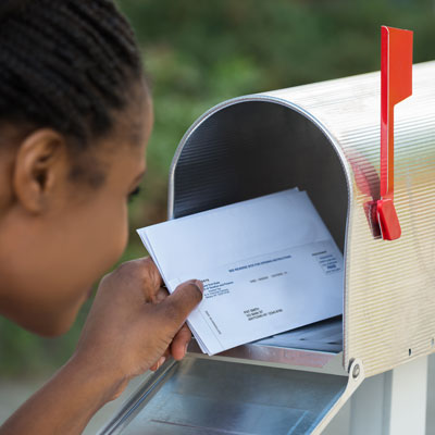 woman taking STAR credit check out of mailbox