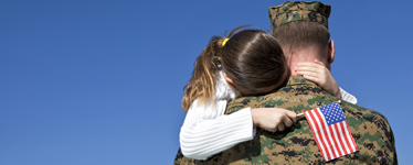 man in military hugging young girl
