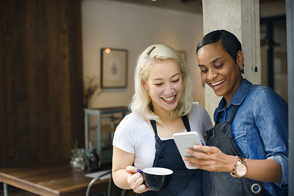 Two business women looking at a cell phone