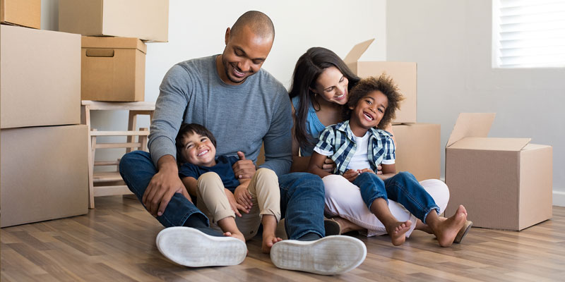 family sitting on the floor with boxes around them